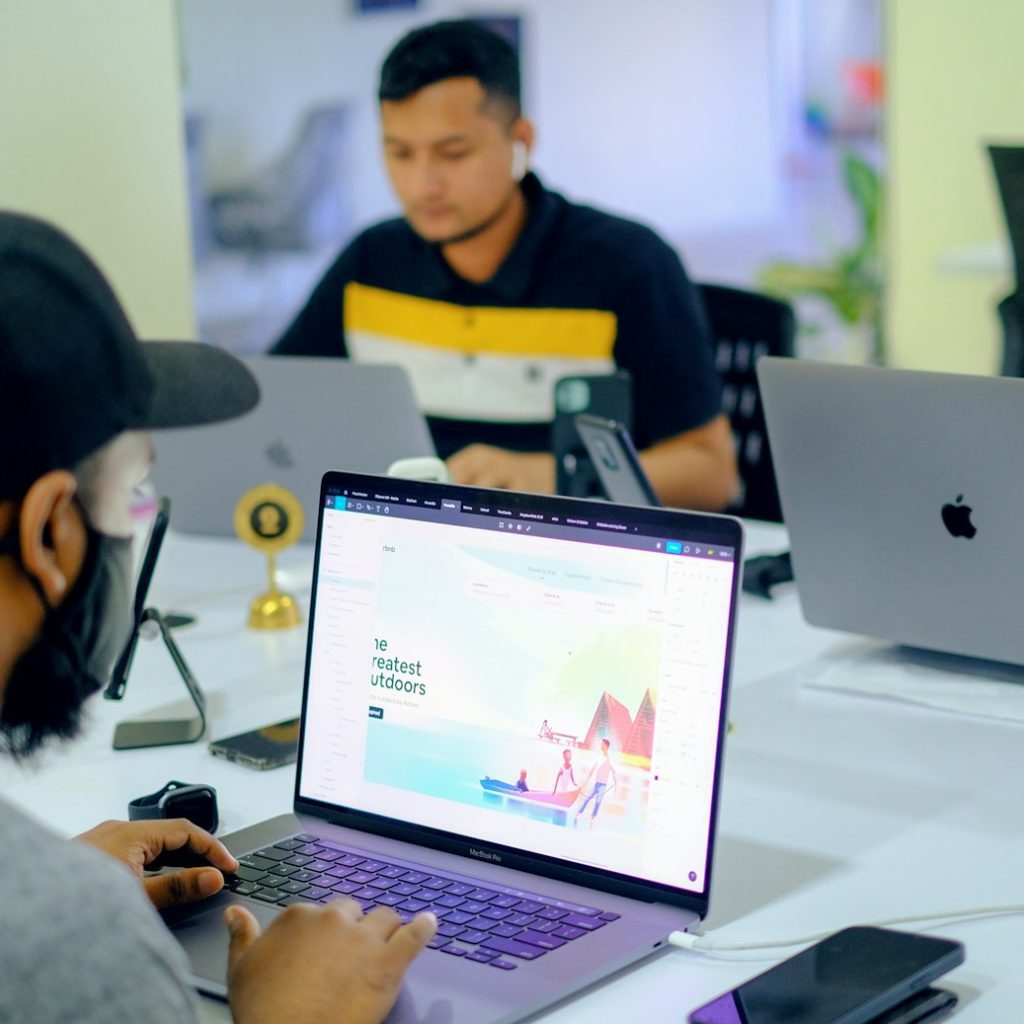 man in gray jacket using macbook pro